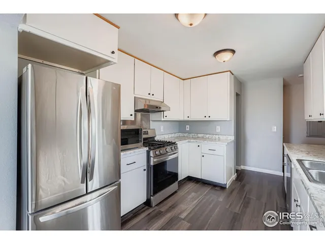 a kitchen with a refrigerator sink and cabinets