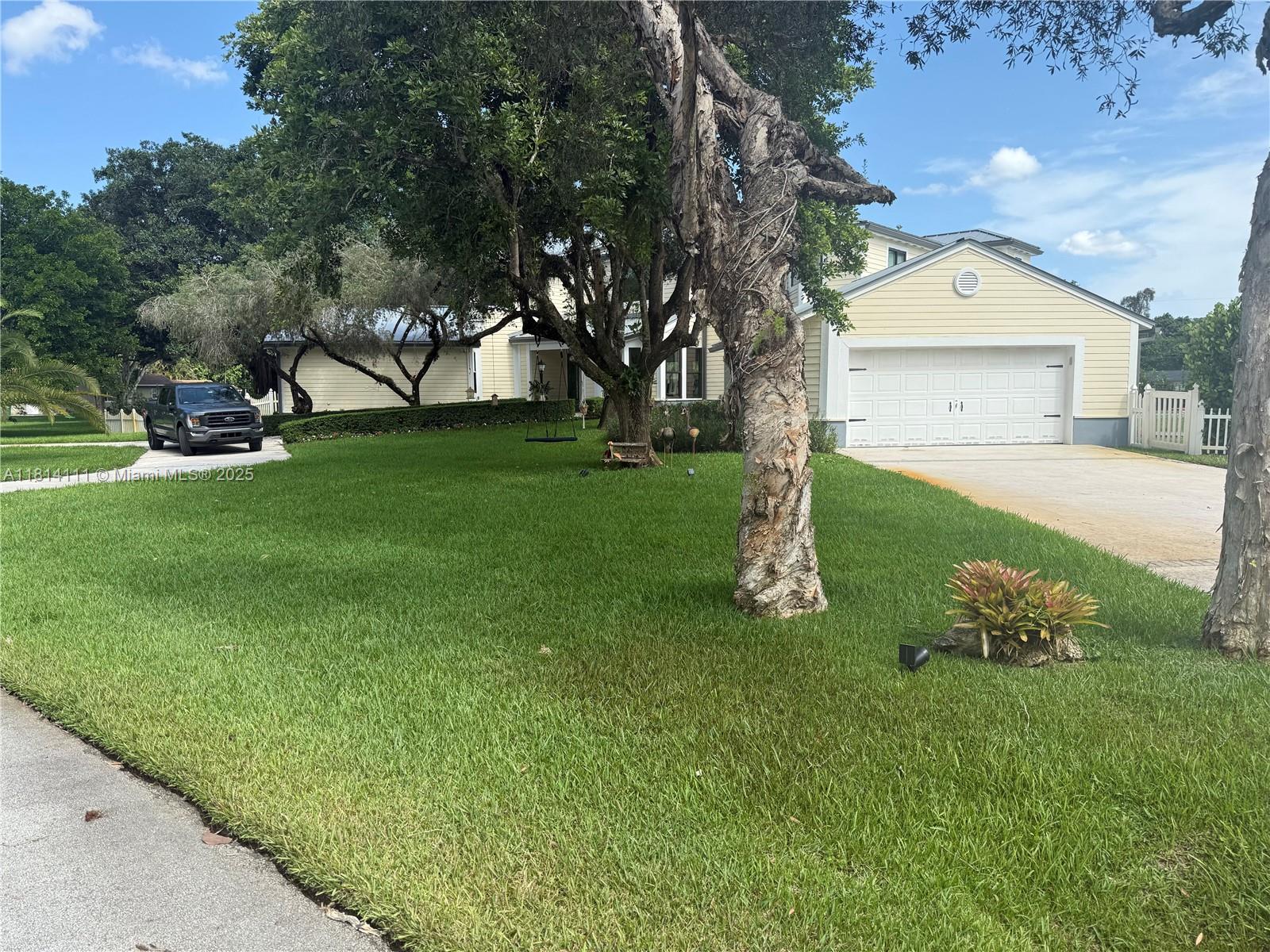 11820 Northwest 5th Street Plantation, FL 33325 - Photo 2 of 6 a front view of a house with garden