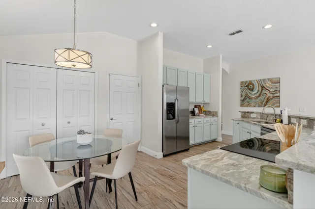 a kitchen with a table chairs stove and refrigerator