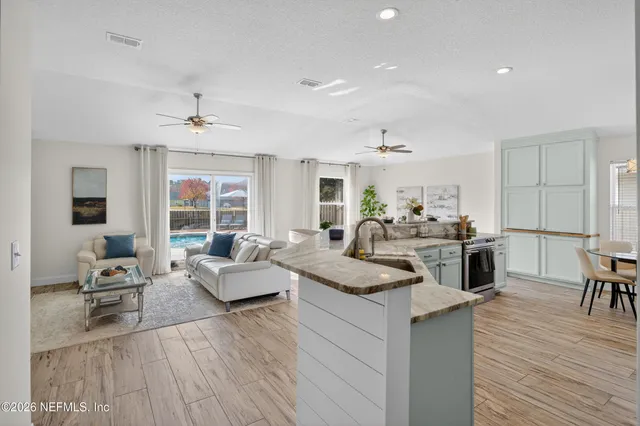 a living room with granite countertop furniture kitchen view and a wooden floor