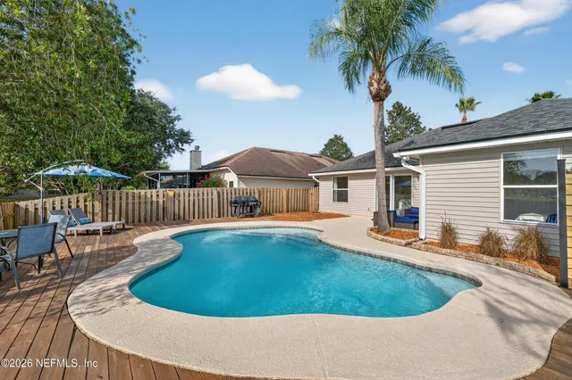 a view of backyard with swimming pool and outdoor seating