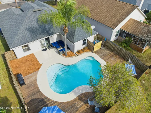 an aerial view of a house with swimming pool and patio