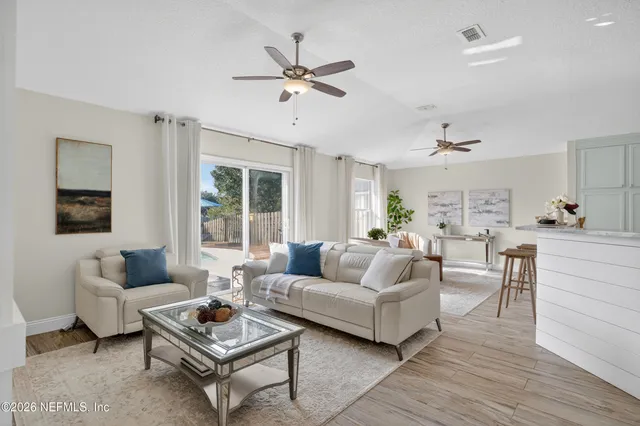 a living room with furniture a ceiling fan and a window
