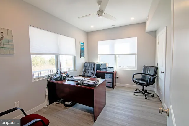 a view of a workspace with furniture and a window