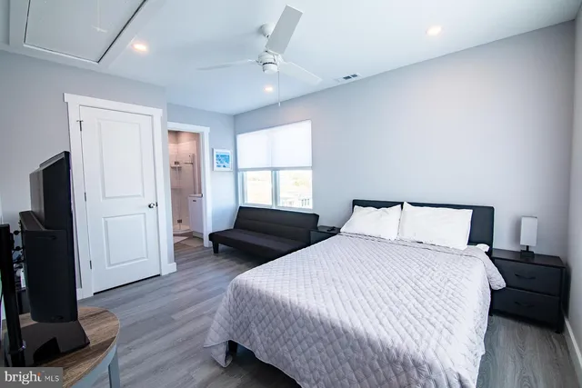 a bedroom with a bed and wooden floor