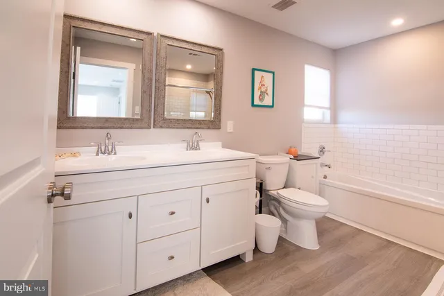 a bathroom with a toilet a sink and a large mirror