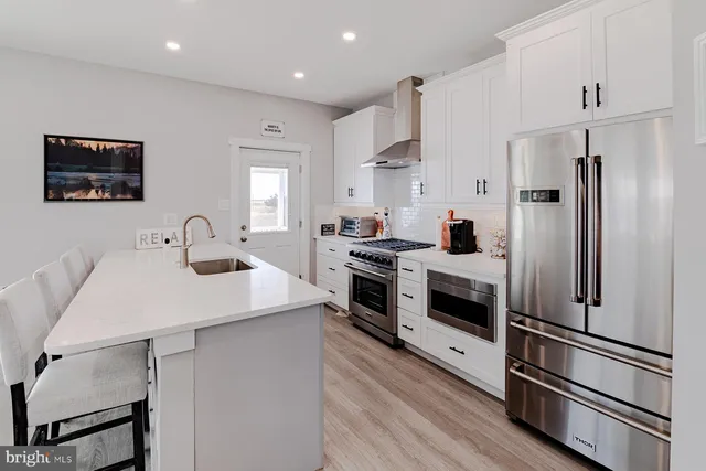 a kitchen with white cabinets and stainless steel appliances