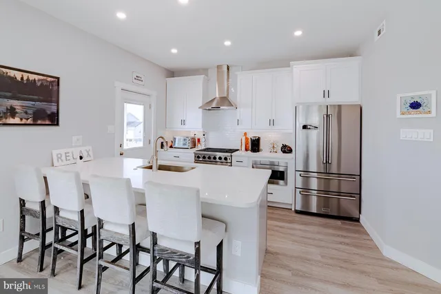 a kitchen with stainless steel appliances a refrigerator and a stove top oven