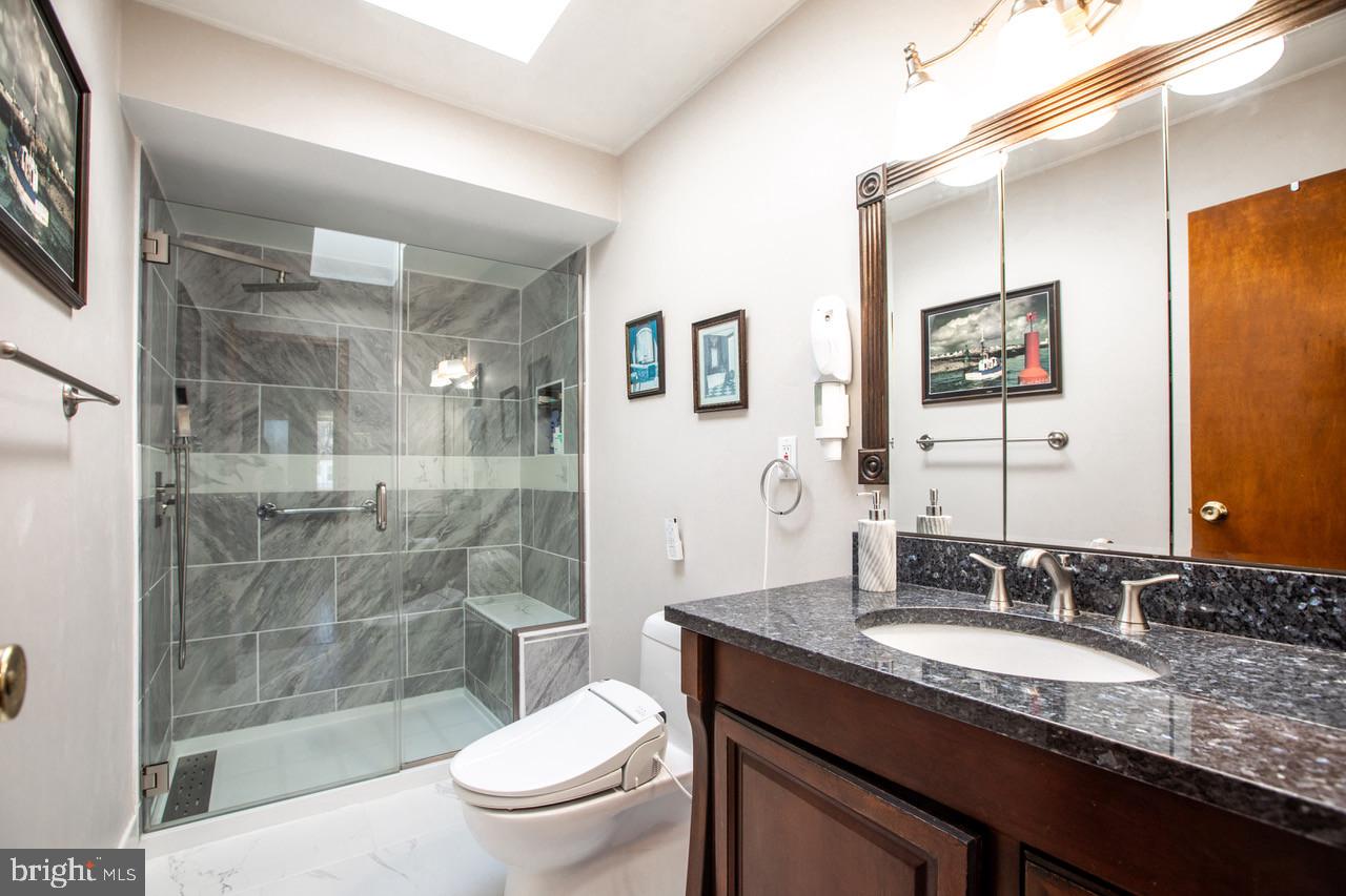 38 Albemarle Road Hamilton, NJ 08690 - Photo 23 of 39 a bathroom with a granite countertop sink a toilet a mirror and shower