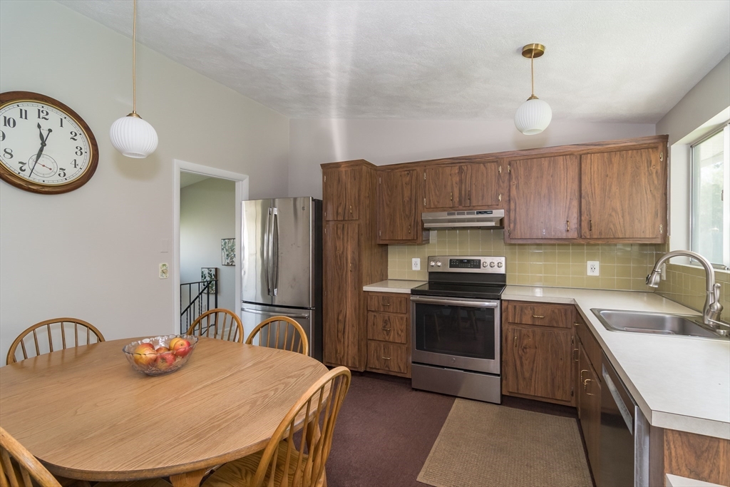 9 Clearview Drive Natick, MA 01760 - Photo 12 of 27 a kitchen with stainless steel appliances granite countertop a sink a stove a refrigerator cabinets and a dining table
