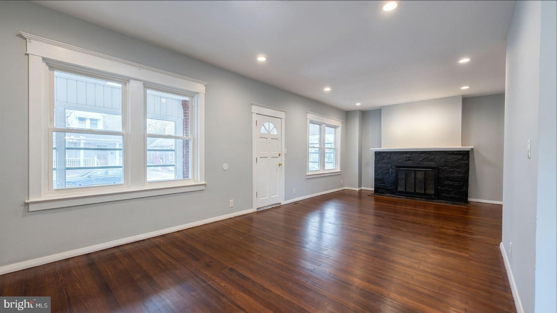 154 Andrew Street Hamilton, NJ 08610 - Photo 4 of 29 an empty room with wooden floor fireplace and windows