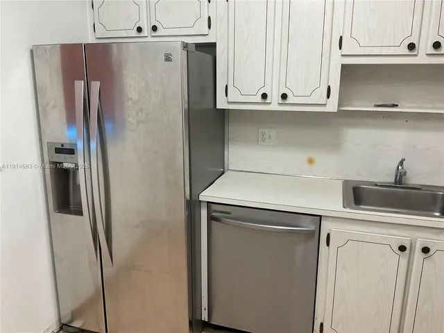 a kitchen with stainless steel appliances a refrigerator and cabinets
