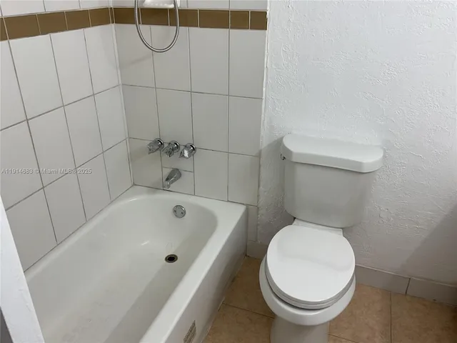 a white toilet sitting next to a bath tub