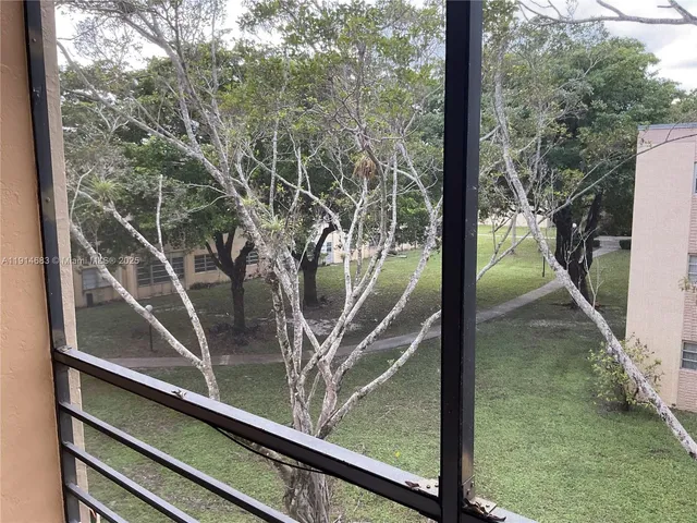 a view of swimming pool with lawn chairs under an umbrella