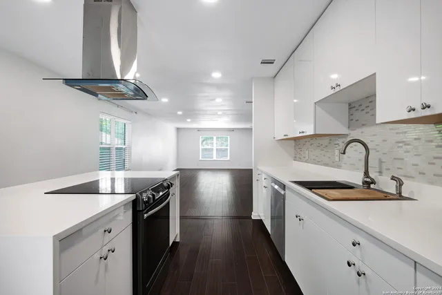 a kitchen with granite countertop a sink stainless steel appliances and counter space