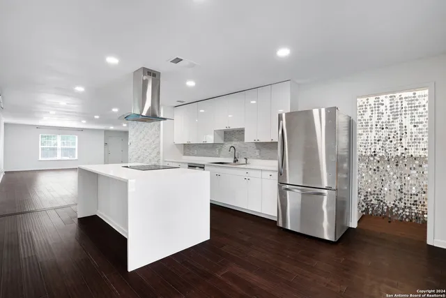 a kitchen with a refrigerator and white cabinets