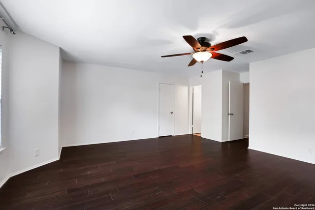 a view of an empty room with wooden floor
