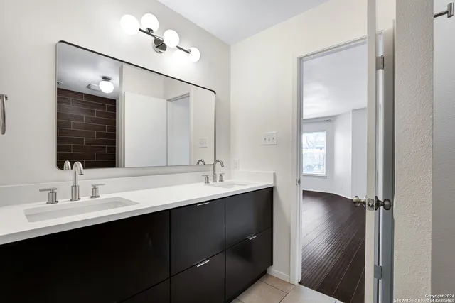 a bathroom with a double vanity sink and mirror