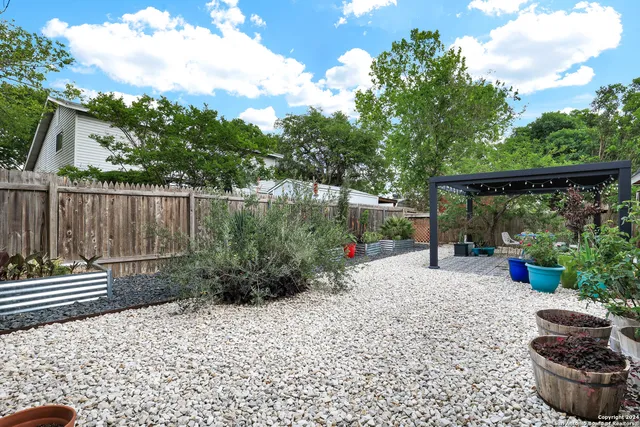 a backyard of a house with plants and outdoor seating