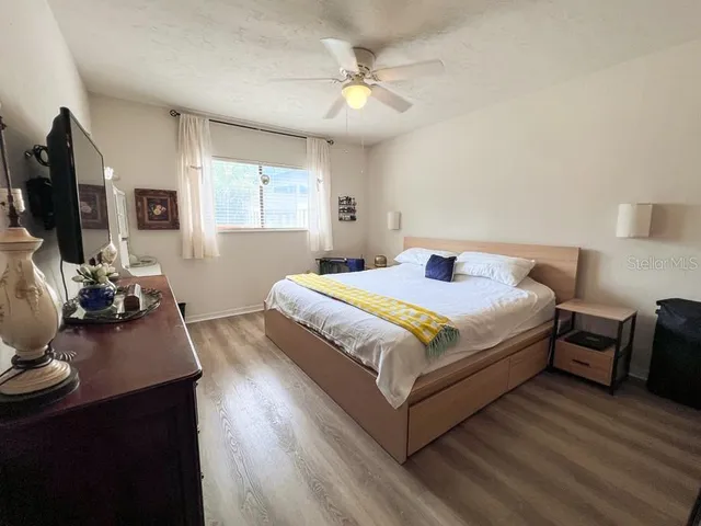 a bedroom with a bed and wooden floor