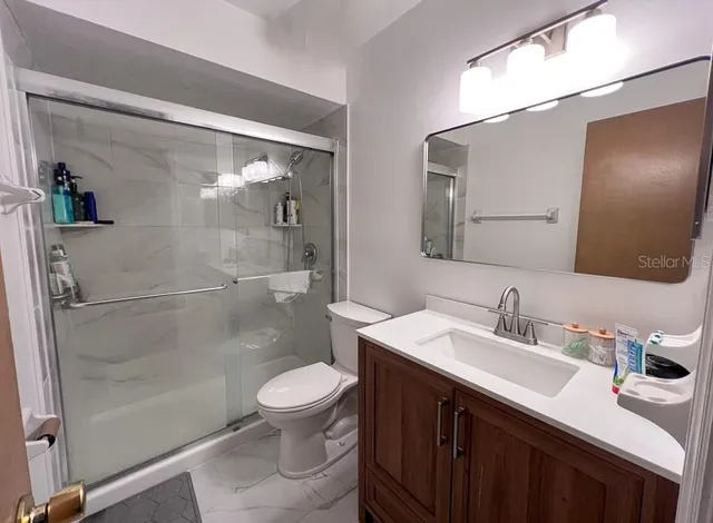 a bathroom with a sink a toilet and shower