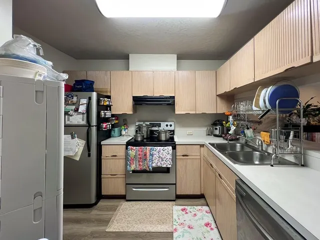 a kitchen with stainless steel appliances granite countertop a refrigerator and a stove top oven