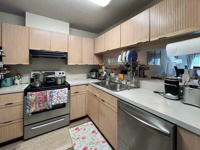 a kitchen with a sink a stove and cabinets