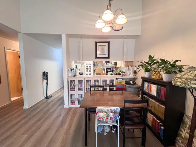 a view of a dining room with furniture a chandelier and wooden floor