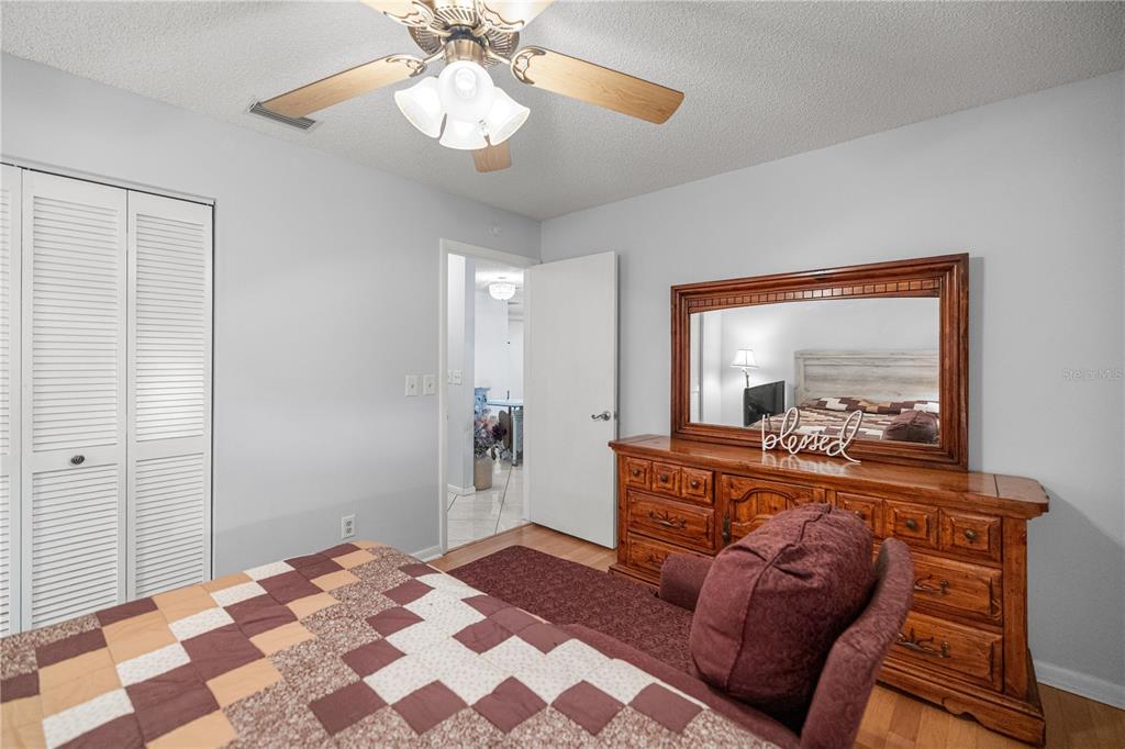 9438 Southwest 85th Avenue, Unit B Ocala, FL 34481 - Photo 15 of 32 a bedroom with a bed and a mirror on dresser