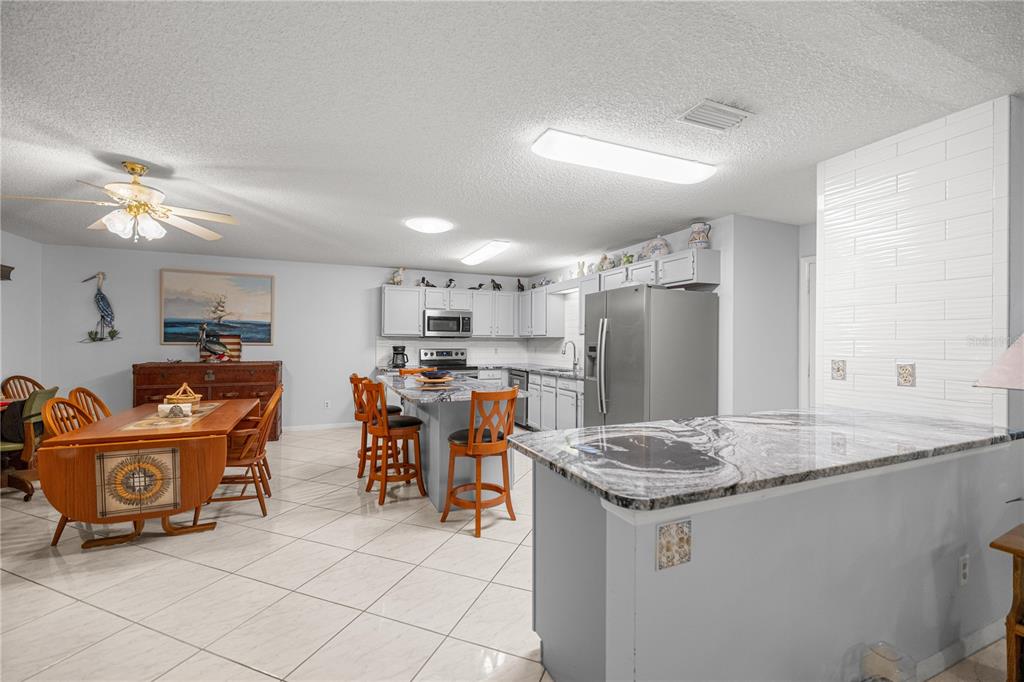 9438 Southwest 85th Avenue, Unit B Ocala, FL 34481 - Photo 7 of 32 a kitchen with stainless steel appliances granite countertop a sink and a refrigerator