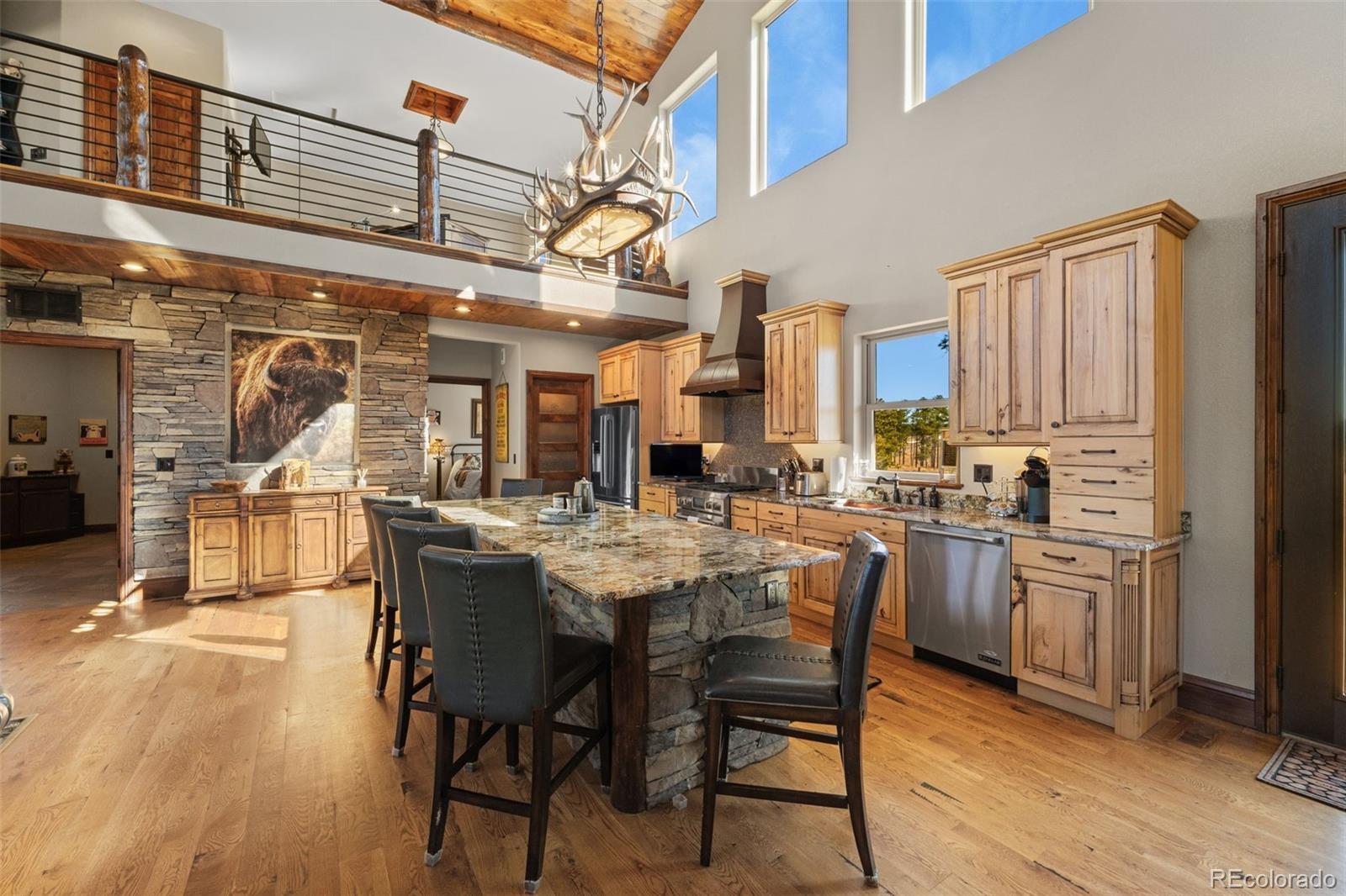 12875 Holmes Road Colorado Springs, CO 80908 - Photo 12 of 50 a kitchen with stainless steel appliances kitchen island granite countertop a table chairs cabinets and wooden floor