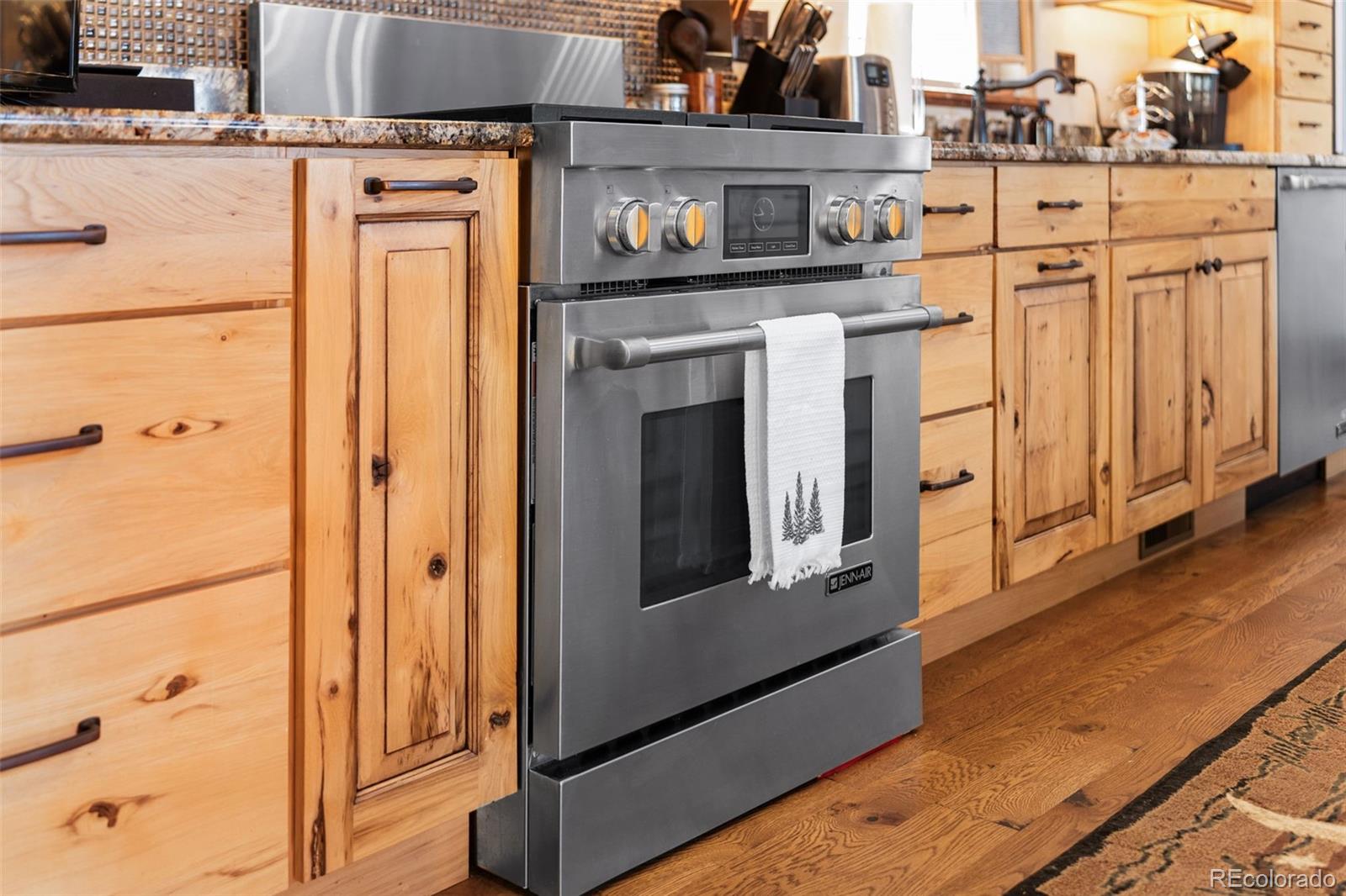 12875 Holmes Road Colorado Springs, CO 80908 - Photo 16 of 50 a kitchen with stainless steel appliances granite countertop a refrigerator and a stove with wooden floor