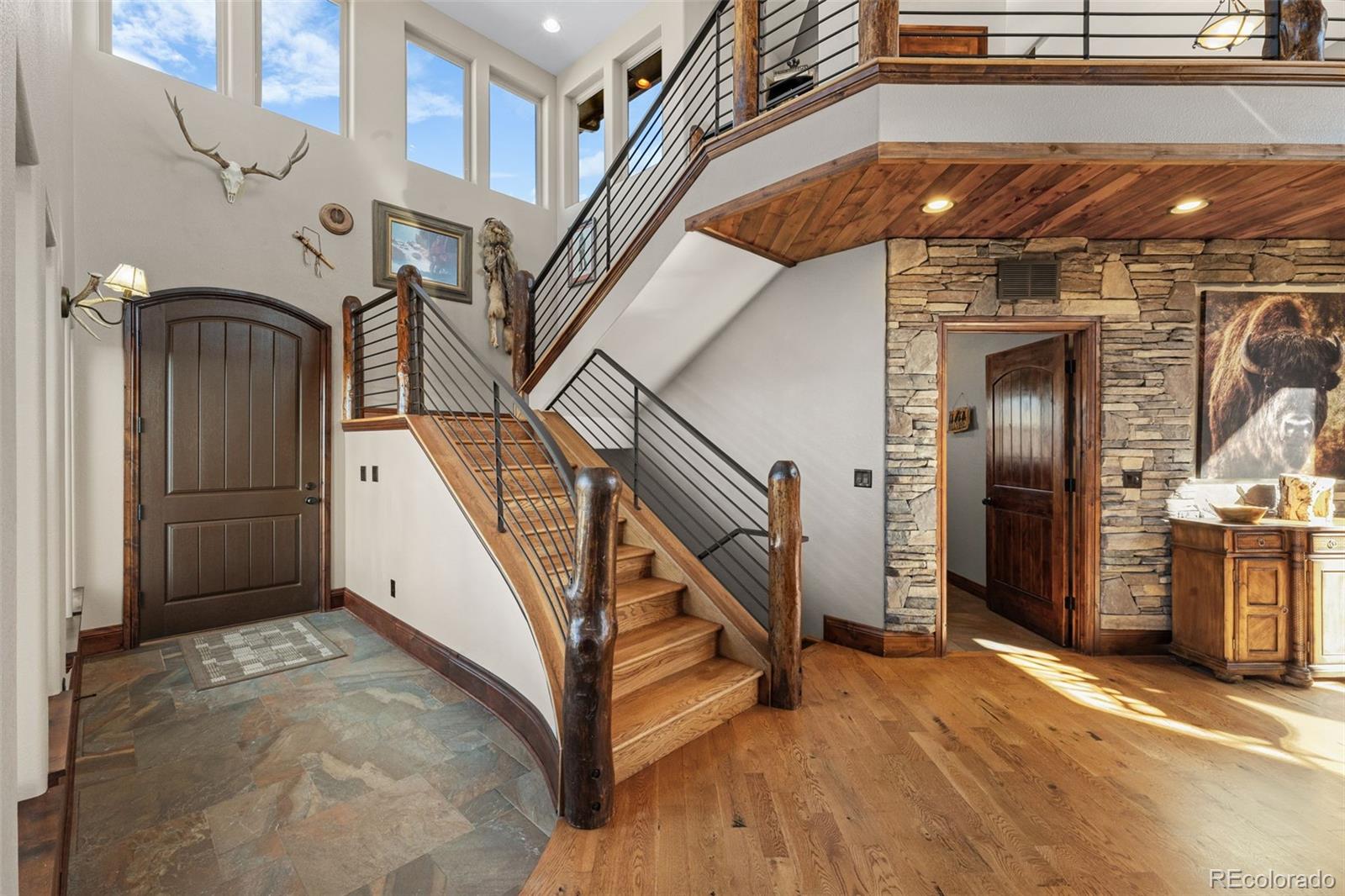 12875 Holmes Road Colorado Springs, CO 80908 - Photo 20 of 50 a view of staircase with lots of frames on wall and a chandelier