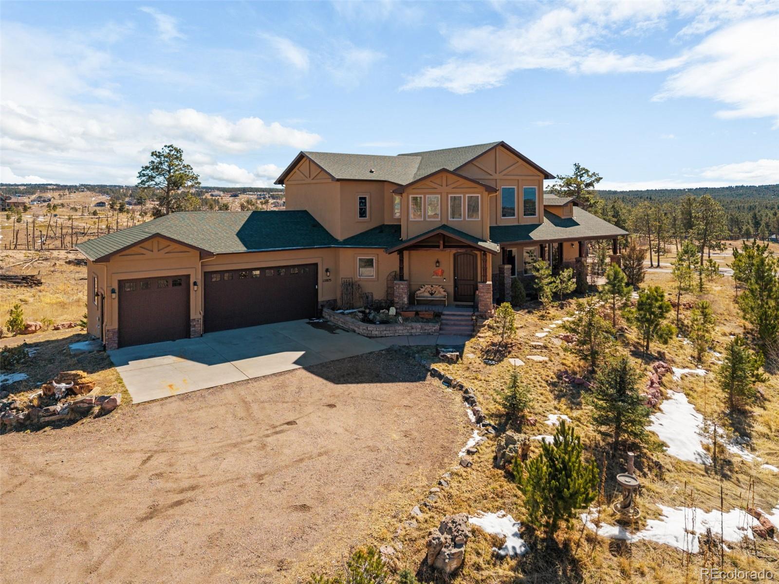 12875 Holmes Road Colorado Springs, CO 80908 - Photo 2 of 50 a front view of a house with a yard covered with snow