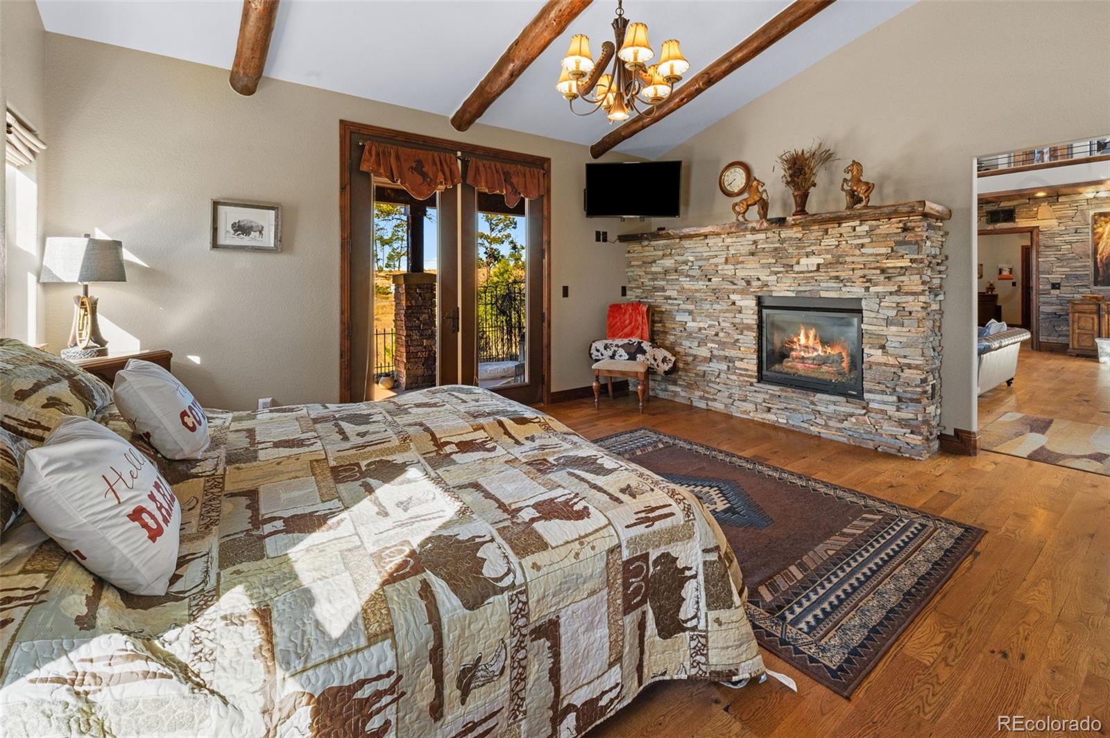 12875 Holmes Road Colorado Springs, CO 80908 - Photo 22 of 50 a bed sitting in a bedroom next to a fireplace