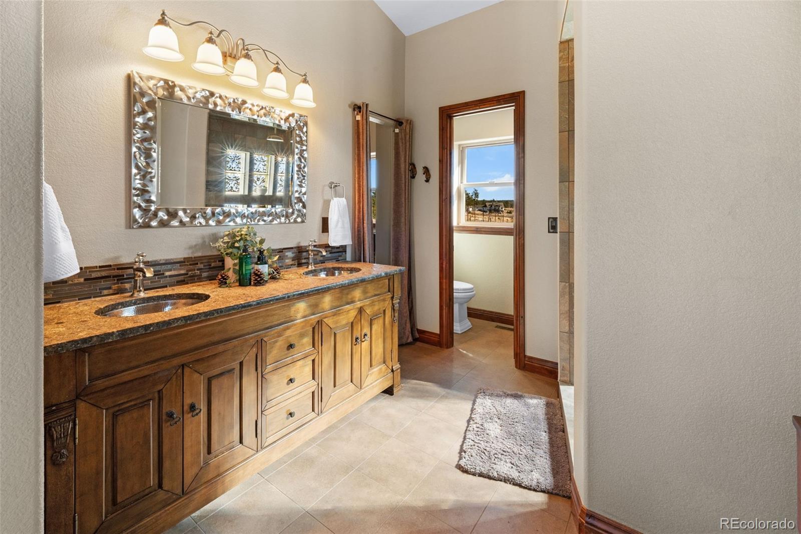 12875 Holmes Road Colorado Springs, CO 80908 - Photo 23 of 50 a bathroom with a sink double vanity and a mirror