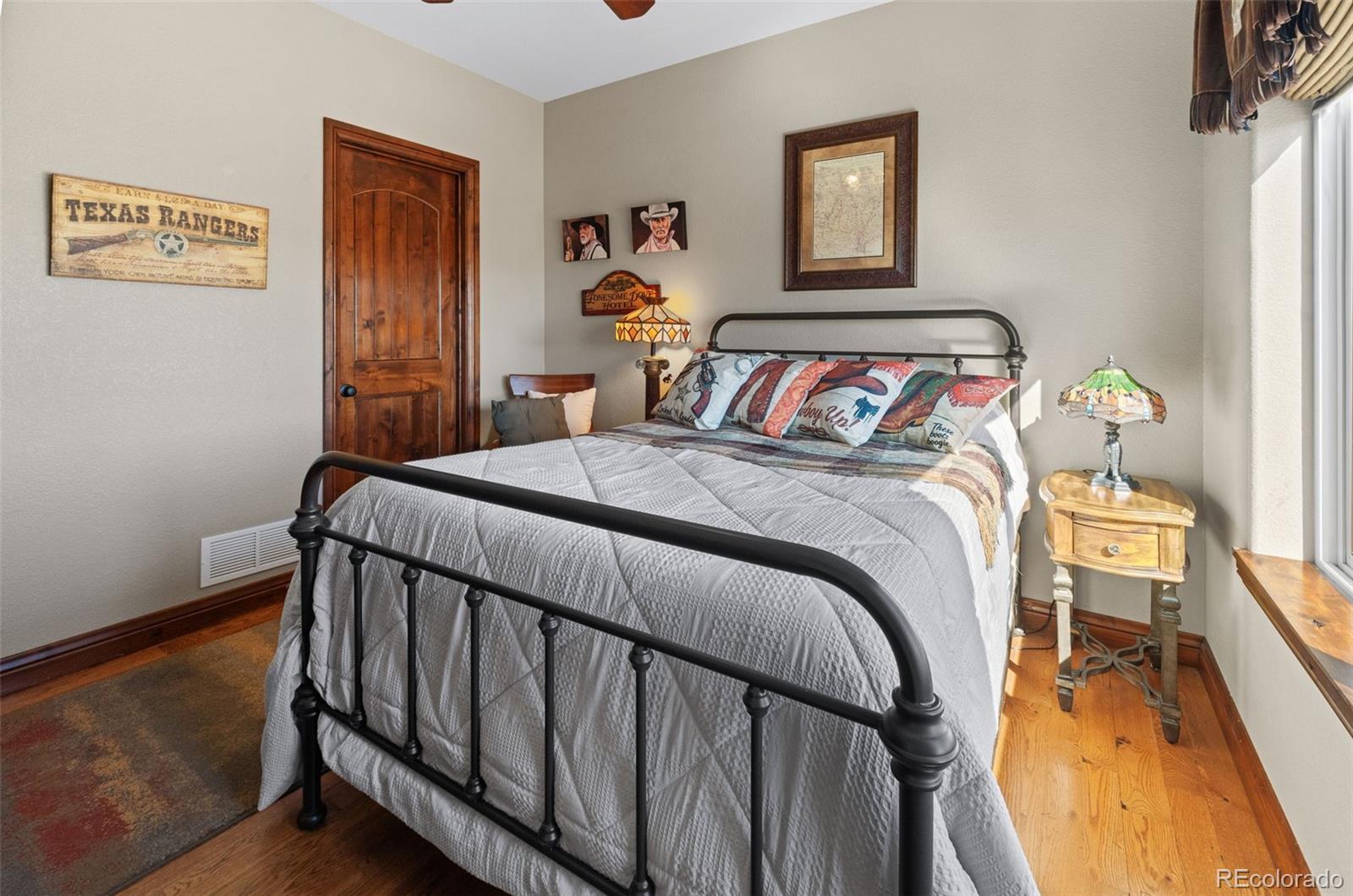 12875 Holmes Road Colorado Springs, CO 80908 - Photo 31 of 50 a bedroom with a bed and wooden floor