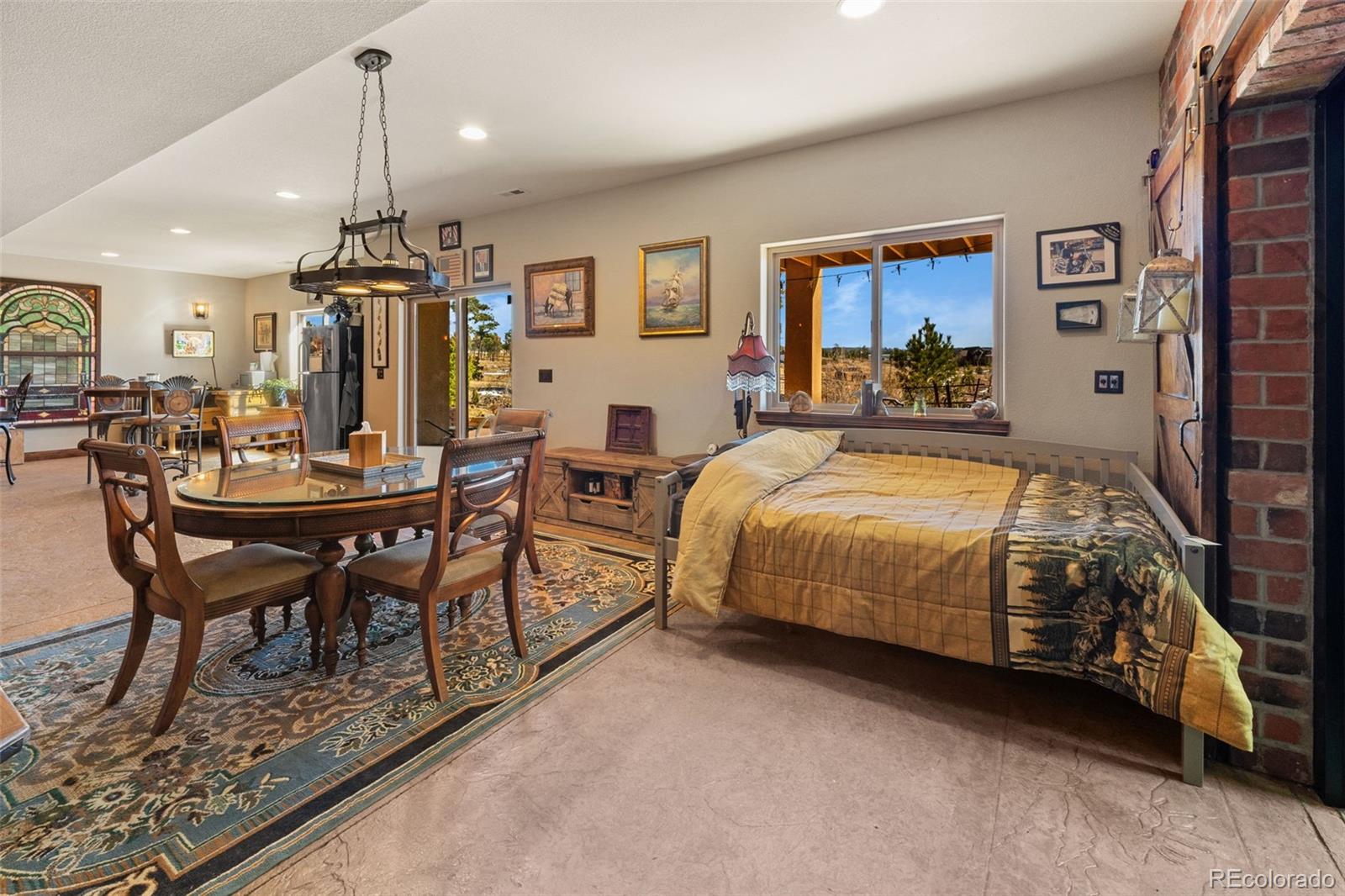 12875 Holmes Road Colorado Springs, CO 80908 - Photo 44 of 50 a spacious bedroom with a bed a table and chairs