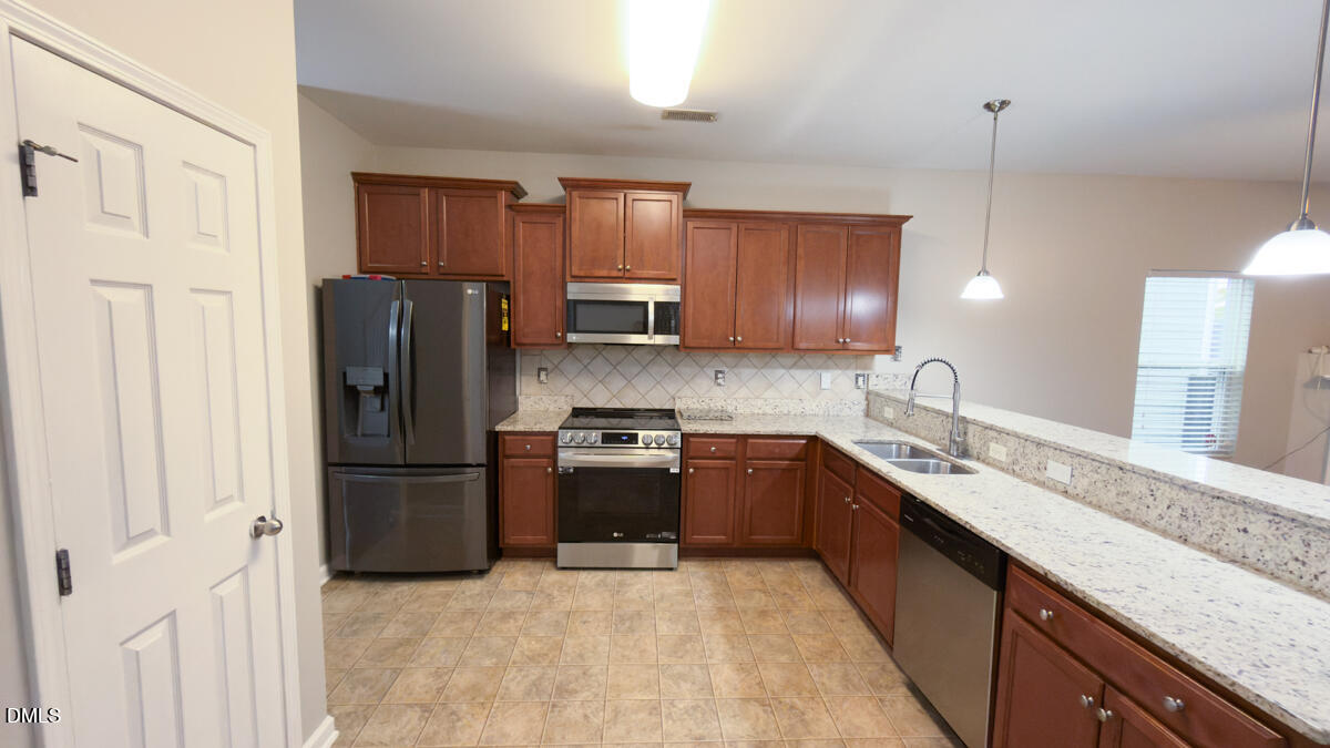 2608 Follow Me Way Raleigh, NC 27610 - Photo 7 of 32 a kitchen with granite countertop stainless steel appliances and refrigerator