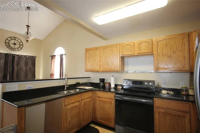 a kitchen with granite countertop a sink cabinets and stainless steel appliances