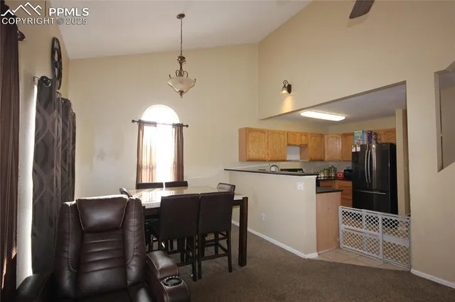 a kitchen with a refrigerator a stove a sink dishwasher with a dining table and chairs