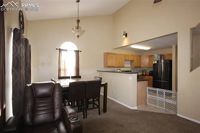 a kitchen with stainless steel appliances kitchen island granite countertop a refrigerator a stove a microwave oven a dining table and chairs with wooden floor