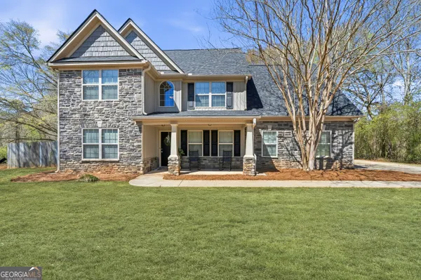 a front view of a house with a yard and trees
