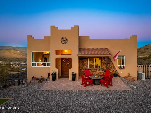 a view of a blue house with many windows next to a yard