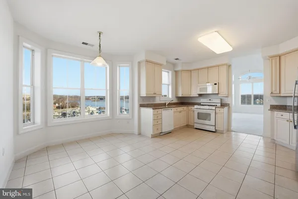 a kitchen with white cabinets and white appliances
