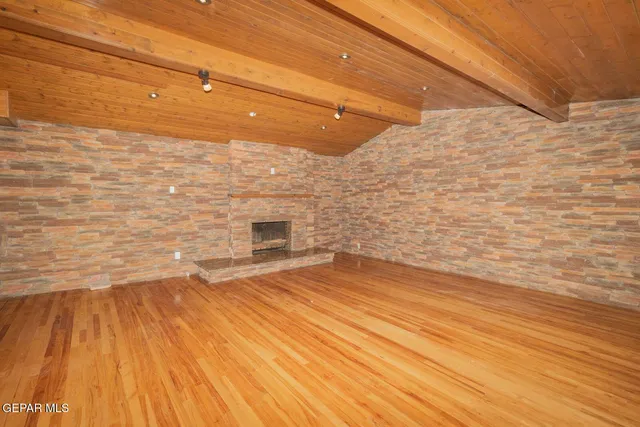 a view of empty room with wooden floor and fireplace