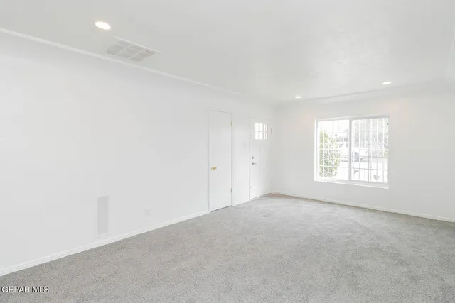 an empty room with a window and a fan