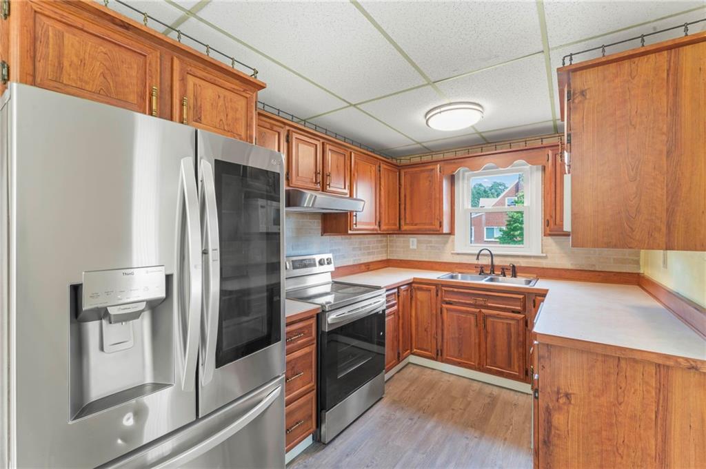 34 Meyers Road Washington, PA 15301 - Photo 15 of 34 a kitchen with stainless steel appliances granite countertop a refrigerator a sink dishwasher a stove and white countertops with wooden floor