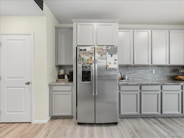 a kitchen with stainless steel appliances white cabinets and wooden floor