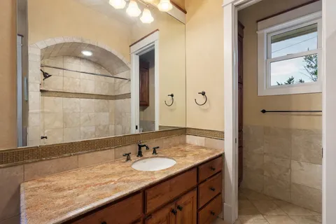 a bathroom with a granite countertop sink and mirror